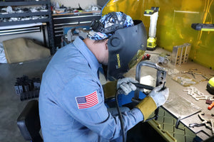 Shawn wearing a face shield and protective gear working on a Custom Hitch Covers